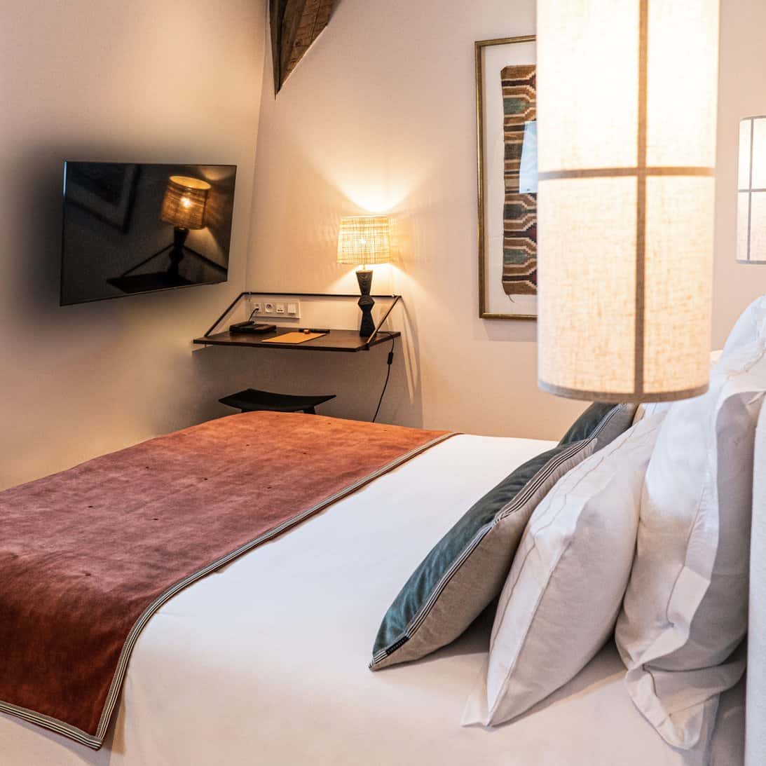 Zoom sur lit, TV et bureau, chambre PMR double confort à Hôtel Le Mosaïque Narbonne.