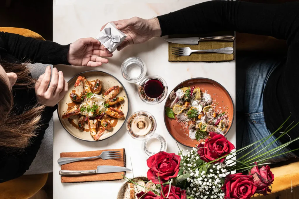 Couple romantique partageant un dîner aux chandelles avec roses rouges au restaurant Le Mosaïque Narbonne